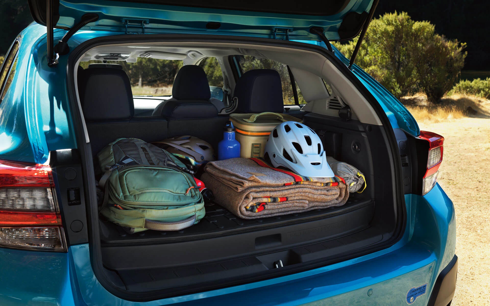 A backpack, blanket, and bike helmet in the rear cargo area of a Crosstrek Hybrid | Romano Subaru in Syracuse NY