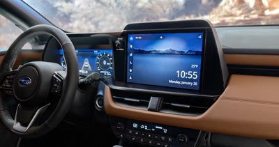 A Subaru Multimedia in-dash touchscreen, steering wheel, and center console.