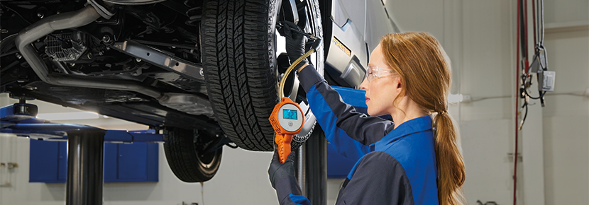 A Subaru technician checking tire pressure. | Romano Subaru in Syracuse NY