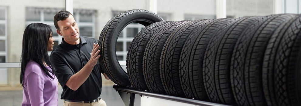Subaru service representative showing customer a tire. | Romano Subaru in Syracuse NY