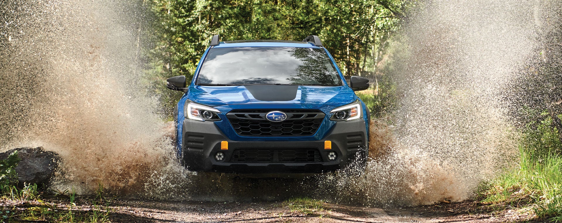 A 2023 Outback Wilderness driving on a muddy trail. | Romano Subaru in Syracuse NY